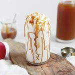 white milkshake in a glass with caramel drizzle